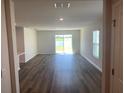 Bright living room featuring wood floors, neutral walls, and sliding glass doors with outdoor views at 10257 Kalamazoo Pl, Parrish, FL 34219