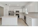 Contemporary kitchen with stainless steel appliances, white cabinets and countertop island at 4285 Big Sky Dr, Spring Hill, FL 34604