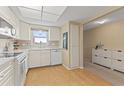 Bright kitchen with white cabinets and wood flooring at 5575 Gulf Blvd # 438, St Pete Beach, FL 33706