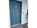 Condo building entry with a blue door and neutral color scheme at 445 Hamden Dr # 505, Clearwater Beach, FL 33767