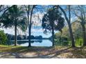 Scenic view of a serene lake framed by mature trees and lush vegetation at 2400 Pine Hammock, Clearwater, FL 33764