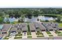 Aerial view of luxury homes overlooking a tranquil lake with lush greenery surrounding the community at 281 Villa Corte Dr, Lutz, FL 33549