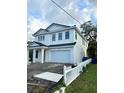 White two-story home featuring an attached two car garage and a white picket fence at 318 W Park Ave, Tampa, FL 33602