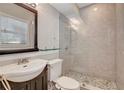 Modern bathroom featuring glass enclosed shower, stone flooring, sleek fixtures, and large mirror at 201 6Th S St # 106, St Petersburg, FL 33701