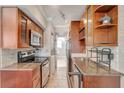 Galley kitchen featuring granite countertops, stainless steel appliances, and beautiful cabinetry, with a laundry room down the hall at 201 6Th S St # 106, St Petersburg, FL 33701