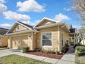 Inviting home features a manicured lawn, two-car garage, and a welcoming walkway with lush landscaping at 20308 Oak Key Ct, Tampa, FL 33647