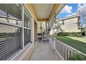 Relaxing covered porch with white railing, comfortable seating, and views of the beautifully landscaped yard at 20308 Oak Key Ct, Tampa, FL 33647