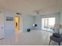 Living room with tile floors, sliding doors to patio, and view of bathroom at 2001 Greenbriar Blvd # 5, Clearwater, FL 33763