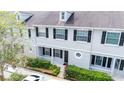 Two-story townhome with gray exterior, black shutters, and landscaping at 34846 Teeview Ln, Zephyrhills, FL 33541