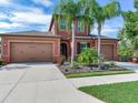 Two-story house with a two-car garage, palm trees, and a landscaped front yard at 31982 Bourneville Ter, Wesley Chapel, FL 33543