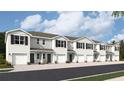 Exterior view of townhomes with two-car garages and attractive landscaping at 17773 Crescent Moon Loop, Lakewood Ranch, FL 34211