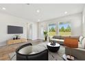 Bright living room with large windows, neutral decor, and sleek furnishings at 11814 Richmond Trl, Parrish, FL 34219