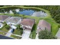 Aerial view of a neighborhood with houses and a pond at 25151 Geddy Dr, Land O Lakes, FL 34639