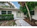 House entrance with light green door, brick walkway, and landscaping at 1001 Chinaberry Rd, Clearwater, FL 33764