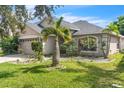 One-story house with a two-car garage, palm tree, and well-manicured lawn at 11131 Irish Moss Ave, Riverview, FL 33569