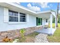 Inviting home entrance with stone accents and a covered front porch area at 233 W College Ave, Ruskin, FL 33570