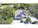 Two-story house with solar panels, elevated ground floor, and a large backyard at 262 Banana Rd, Palm Harbor, FL 34683