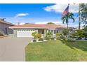 One-story home with landscaped yard, driveway and American flag at 3111 E Vina Del Mar Blvd, St Pete Beach, FL 33706