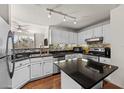 Modern kitchen with white cabinets, granite countertops and stainless steel appliances at 501 Knights Run Ave # 1215, Tampa, FL 33602