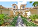 Inviting entrance to a charming two-story building with lush landscaping at 1361 Emerald Dunes, Sun City Center, FL 33573