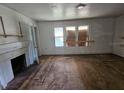 Empty living room with hardwood floors, fireplace and boarded windows at 2220 18Th S St, St Petersburg, FL 33712