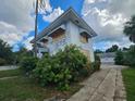 Side view of a fixer-upper house with boarded windows and landscaping at 2220 18Th S St, St Petersburg, FL 33712