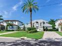 Two-story house with gray metal roof, landscaping, and paved driveway at 2509 N Dundee St, Tampa, FL 33629