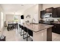 Modern kitchen with island, granite countertops and stainless steel appliances at 16762 Delia St, Wimauma, FL 33598