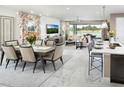 Open concept dining room with seating for six, adjacent to the living room and kitchen at 13714 Heartwood Way, Parrish, FL 34219
