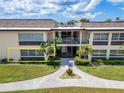 Condo building exterior showcasing landscaping and walkway at 4600 Marine Parkway # 104, New Port Richey, FL 34652