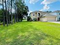 Two-story house with a spacious backyard and lush green landscaping at 5239 Tummel Ct, Wesley Chapel, FL 33545