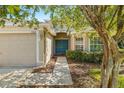 House exterior showcasing a teal front door and landscaped walkway at 9343 Rolling Circle, San Antonio, FL 33576
