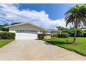 Two-car garage with a white door and a long driveway at 1745 Harbor W Cir, Largo, FL 33770