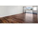 Bright living room with dark brown wood-look flooring and sliding glass doors to balcony at 17920 Gulf Blvd # 205, Redington Shores, FL 33708