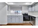 Modern kitchen with light blue cabinets, stainless steel appliances, and dark brown wood-look flooring at 17920 Gulf Blvd # 205, Redington Shores, FL 33708