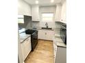 Renovated kitchen featuring modern appliances, granite countertops, and white cabinetry at 6000 2Nd E St # 6, St Pete Beach, FL 33706