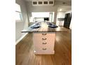 Modern kitchen island featuring a breakfast bar, storage, and elegant countertop at 6000 2Nd E St # 6, St Pete Beach, FL 33706