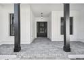 Brick paved porch with black columns and a black front door at 4817 Majestic Hills Loop, Brooksville, FL 34601