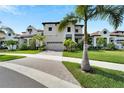 Two story house with beige exterior, palm trees, and brick driveway at 2636 Yellow Sundial Loop, Ruskin, FL 33570