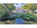 Aerial view of a waterfront home with a lovely backyard, deck, private dock, and lush green trees at 1155 7Th N St, Safety Harbor, FL 34695