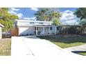 Inviting single-story home featuring a charming front porch and well-maintained lawn under a bright sky at 1155 7Th N St, Safety Harbor, FL 34695