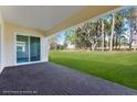 View of an outdoor covered brick porch with a backyard at 4638 Southern Valley Loop, Brooksville, FL 34601