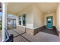 Covered porch with a brick floor leading to an attractive blue front door at 4638 Southern Valley Loop, Brooksville, FL 34601