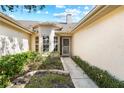 Inviting entryway to the home with a walkway lined with greenery at 2989 Brookfield Ln, Clearwater, FL 33761