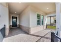 Cozy covered porch with brick accents, offering a welcoming entrance with black metal railings at 4656 Southern Valley Loop, Brooksville, FL 34601