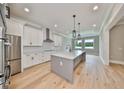 Open concept kitchen boasts white cabinets, a large island, and hardwood floors at 3812 W Sevilla St, Tampa, FL 33629
