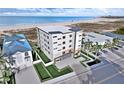 Beachfront view of The Pearl building, featuring parking and landscaping at 10126 Gulf Blvd # Ph1, Treasure Island, FL 33706