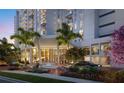 Elegant building entrance with palm trees, manicured landscaping, and a water feature leading to a glass entryway at 5701 Bowen Daniel Dr. # 504, Tampa, FL 33616