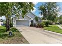 Two-story house with gray siding, attached garage, and landscaped yard at 6228 Dainty Bess Ct, Land O Lakes, FL 34639