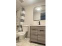 Updated bathroom with gray vanity, white toilet and striped shower curtain at 3002 W Cleveland St # E1, Tampa, FL 33609
